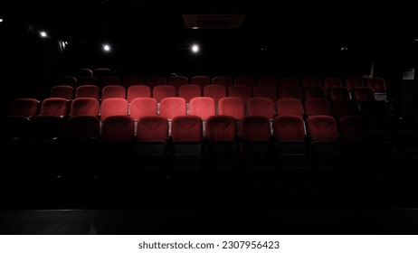 stage light hitting red cloth seats in theater , movie theater