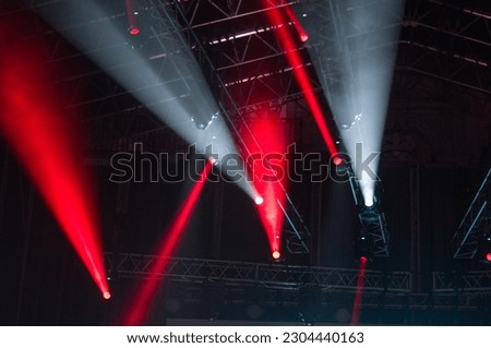 Stage lights during a concert. Light cannons project colored beams of light in different directions
