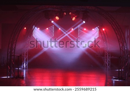 A stage with lights and a red arch. The stage is empty