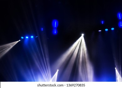 Stage lights. Several projectors in the dark. Multi-colored light beams from the stage spotlights on the stage in the smoke at the time of the entertainment show. Night club. Lights show. Lazer show - Shutterstock ID 1369270835