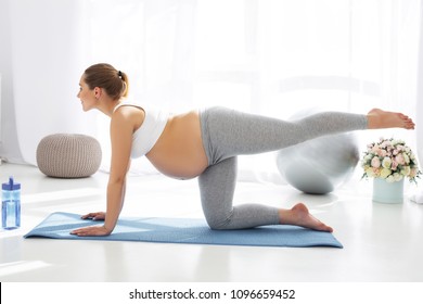 Stage Of Pregnancy. Pleasant Pregnant Woman Posing In Profile And Trying Yoga