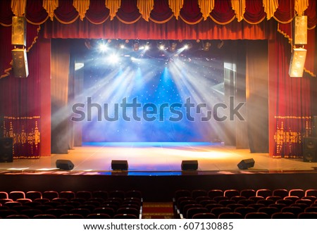The stage of the theater illuminated by spotlights and smoke from the auditorium