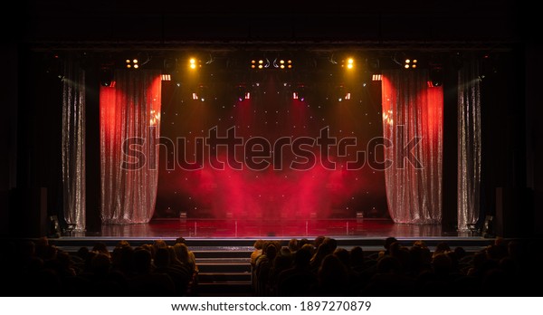 The stage of the theater illuminated by\
spotlights from the\
auditorium