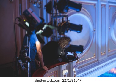 Stage worker assistant sets up lights, light engineer, lighting technician adjusting lights for concert music show in hall, installation of professional equipment with projectors and led lights - Powered by Shutterstock