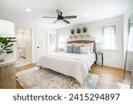 Staged bedroom interior with wooden floors, bright spacious rooms with decor clean crisp linens bedding throw pillows hardwood floors and ocean view