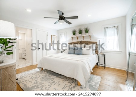 Staged bedroom interior with wooden floors, bright spacious rooms with decor clean crisp linens bedding throw pillows hardwood floors and ocean view