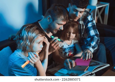   Staged photo  Homosexual couple   their children  two cute girls  at home    They are all sitting together   drawing and markers in notebook  Let's see what we drew!                          