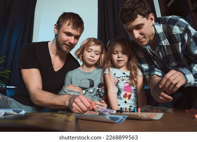  Staged photo  Homosexual couple   their children  two cute girls  at home  Well  little girl  count it   put it down! Don't frown  you have to know how to lose      