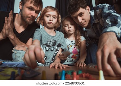    Staged photo  Homosexual couple   their children  two cute girls  at home  Everybody plays and delight  Don't try to cheat  little girl! I can do it better than yo
