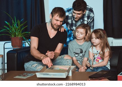    Staged photo  Homosexual couple   their children  two cute girls  at home   An everyday evening after day's work 
