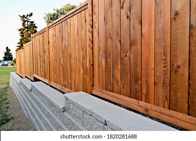 Staggered retaining block wall, cement blocks, new construction, wooden fence, panel fence,  residential property,  - Shutterstock ID 1820281688