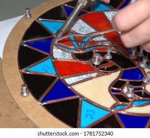 Stain Glass artist solders joints on a project.