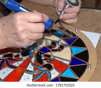 Stain Glass: srtist uses a soldering tool