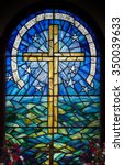 Stained glass window in a church on St Agnes, Isles of Scilly, U.K. Depicting a cross against the sky and sea.