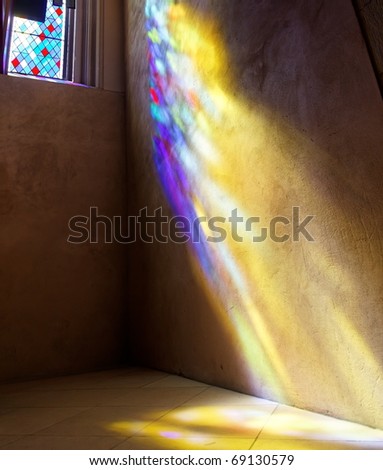 Stained Glass window with sun rays of colored light on wall and floor. St. Giles Cathedral. Edinburgh. Scotland. UK.