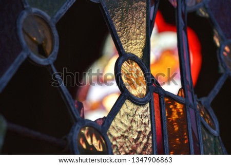 Stained glass/leaded light: damaged leadlight of a French mausoleum backlit by evening sun.