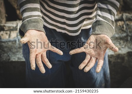 Stained hands are forced to work. The concept of anti-child labor. The abuse of labor. The oppression or intimidation of forced labor among children.