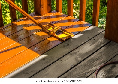 Staining Wooden Deck With Paint Roller; Untreated Patch Of Wood Shown For Contrast