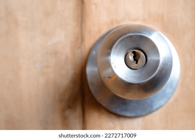 Stainless doorknob and keyhole on old wooden door, Macro shot