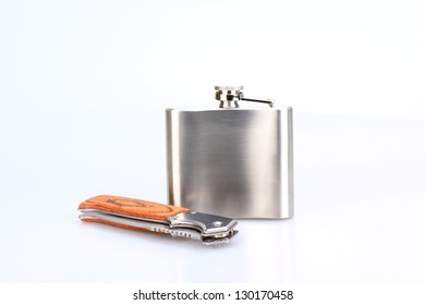 Stainless hip flask and Folder knife isolated on white background