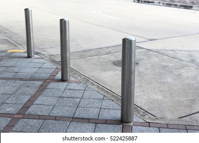 Stainless Steel bollards on grey stone pavement of car park