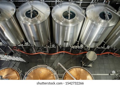 Stainless steel brewing tanks and equipment, iron reservoirs and pipes in modern beer factory. Brewery - Shutterstock ID 1542732266