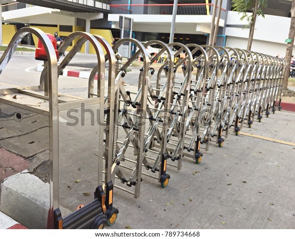 Stainless steel car\
barrier on road with\
wheels