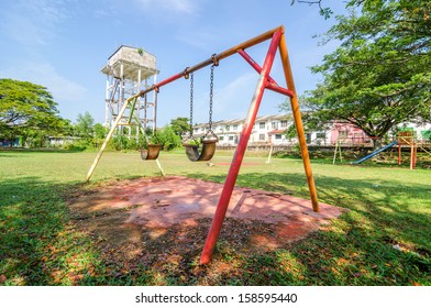 Stainless Steel Childrens Swing Set With Partly Cloudy Blue Sky