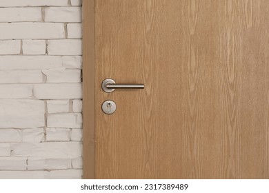 Stainless steel door handle on wooden door. - Powered by Shutterstock