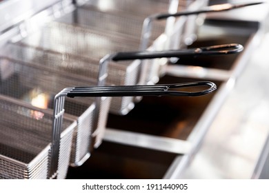 Stainless steel frying baskets in commercial kitchen. - Shutterstock ID 1911440905