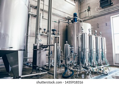 Stainless steel juice factory equipment, large reservoirs or tanks and pipes in modern plat. Industrial background - Powered by Shutterstock