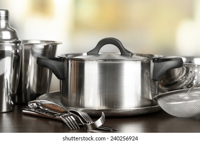 Stainless steel kitchenware on table, on light background - Shutterstock ID 240256924