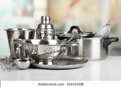 Stainless steel kitchenware on table, on light background - Shutterstock ID 243141508