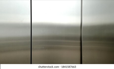 Stainless Steel Large Sheet  With Light Hitting The Surface  For Background,Inside Passenger Elevator,Reflection Of Light On A Shiny Metal Surface,stainless Steel Background.