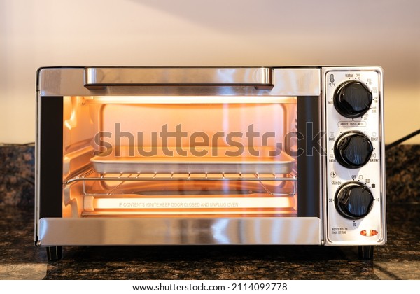 Stainless steel modern design toaster oven is\
on the granite kitchen\
countertop