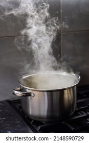 Stainless Steel Pot On A Gas Stove With Boiling Water And Steam