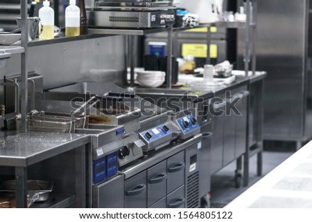 Stainless steel restaurant professional kitchen equipment and work surface. The indoor kitchen. None of the people. The light was on