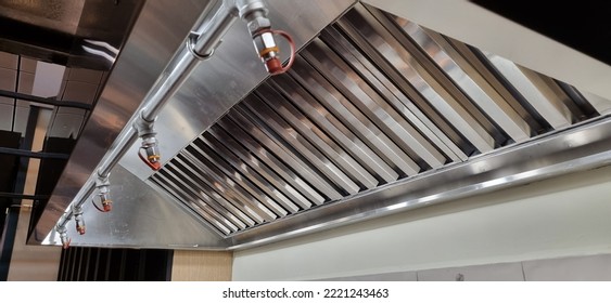 Stainless Steel shiny exhaust hood with grease baffles and fire suppression system - Shutterstock ID 2221243463