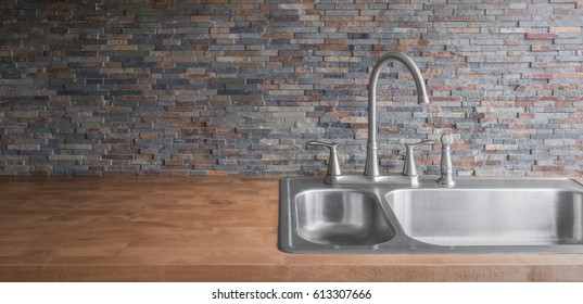 stainless steel sink and wooden kitchen counter and stone backsplash background