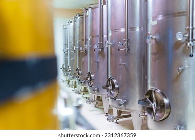 Stainless steel tank barrels in a brewery or wine cellar. Alcohol liquor drink manufacturing or and wine winemaking quality control process concept. - Shutterstock ID 2312367359