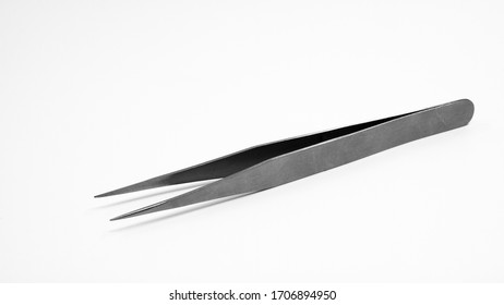 Stainless tweezers on bright background.