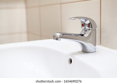 Stainless Water Tap In White Bathroom Sink