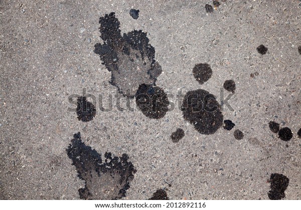 stains from engine oil flowing out of cars, car oil\
stains on an asphalt\
road