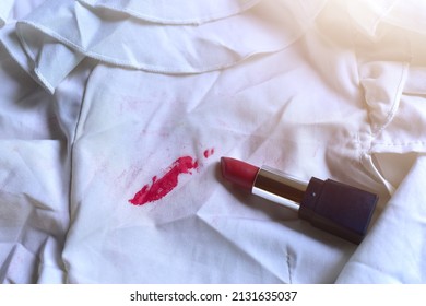 Stains of lipstick or makeup on white clothes or stains on clothes from everyday accidents. Concept of cleaning stains on clothes or cleaning the house. Selected focus - Shutterstock ID 2131635037