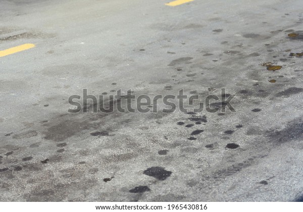Stains on the road from the car oil. Black oil\
stains on the asphalt