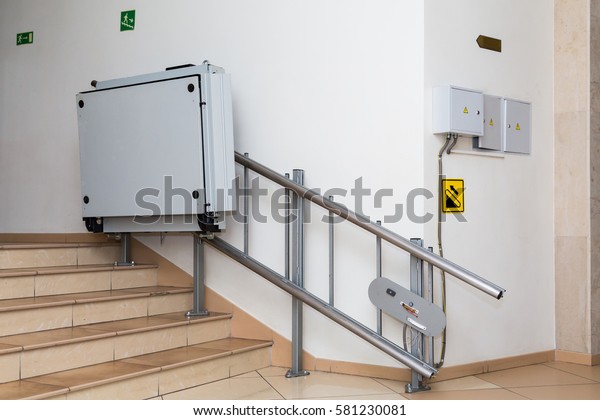Stair\
lift for the disabled. Stairs of public\
building.