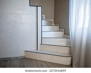 Staircase finished with ceramic tiles and leading to the second floor of the house - Shutterstock ID 2273416859
