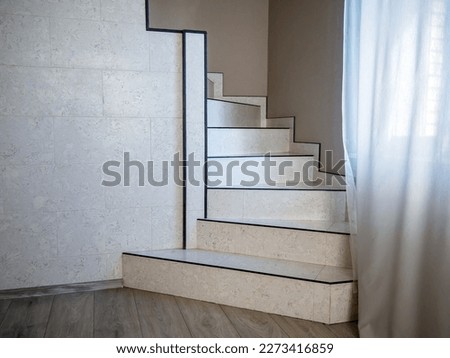 Staircase finished with ceramic tiles and leading to the second floor of the house