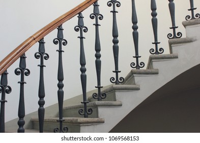 Staircase Handrailing In Old Historic Building. Interior Decor Of Vintage Stairs With Metal Ornament And White Wall Background. House Design Detail Of Historical Stair Case With No People Close Up.