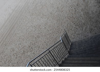 A staircase with a metal handrail leads to the sandy beach, top view - Powered by Shutterstock